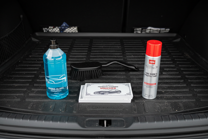 Kit arranged on trunk mat: shampoo vouchers, concentrate bottle, brush attachment, spray can